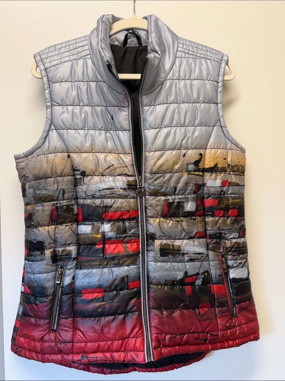 This is an art-printed puffer vest by Dolcezza featuring a striking silver-to-re